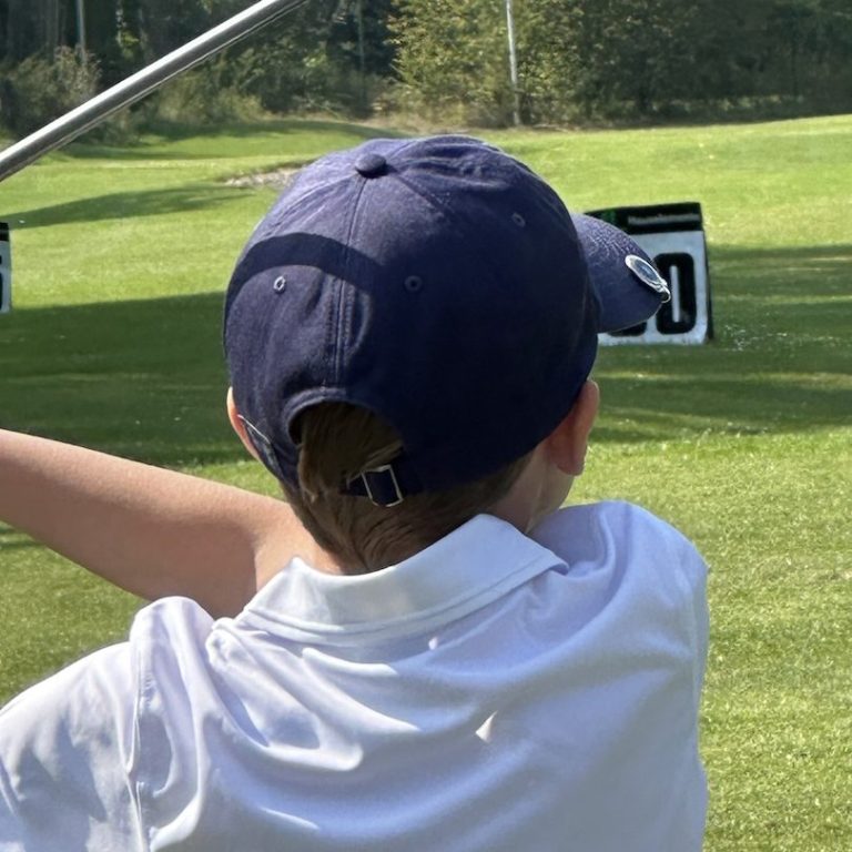 Golfkid beim Abschlag auf der Driving Range