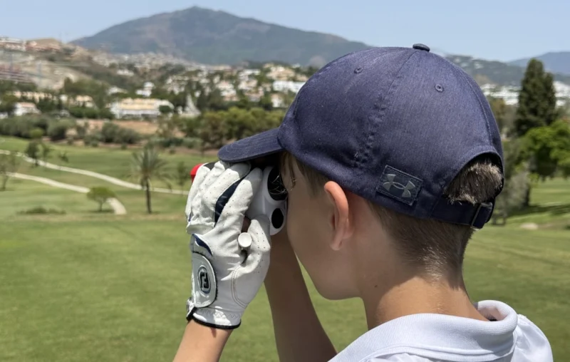 GOLFKIDS.FUN Themenwelt Golf für Kinder und Jugendgolf | Junges Golftalent am Abschlag mit Rangefinder im El Paraiso Golf Club in Spanien